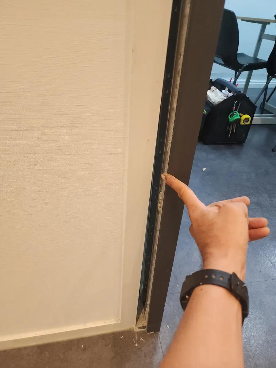 문틀 고정 — 벌어진 틈을 가리킨 모습